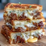 Hearty short rib grilled cheese sandwich, perfectly toasted sourdough with savory shredded beef filling.