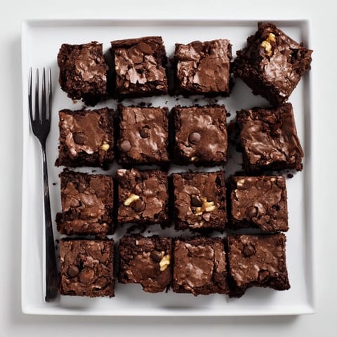A stack of fudgy Brownies with walnuts, showing rich chocolate texture and crumbly edges.