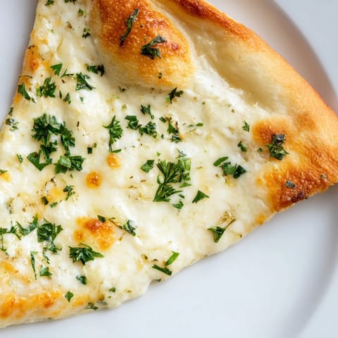 Freshly baked Creamy Garlic White Pizza showing a crisp crust and creamy garlic sauce spread inside.