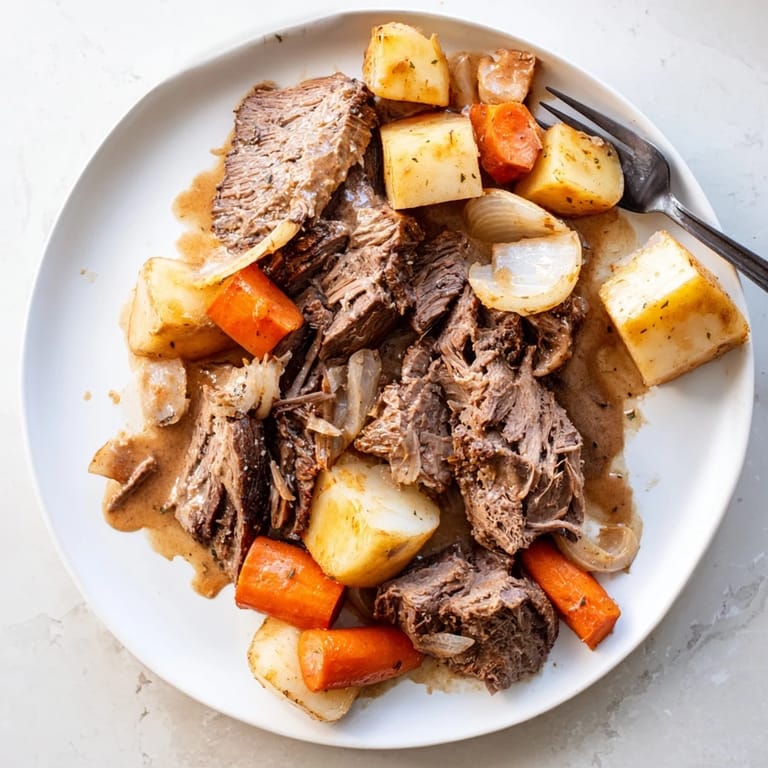Sliced Beef Pot Roast plated with roasted vegetables and a rich, dark gravy, perfect for Sunday supper.