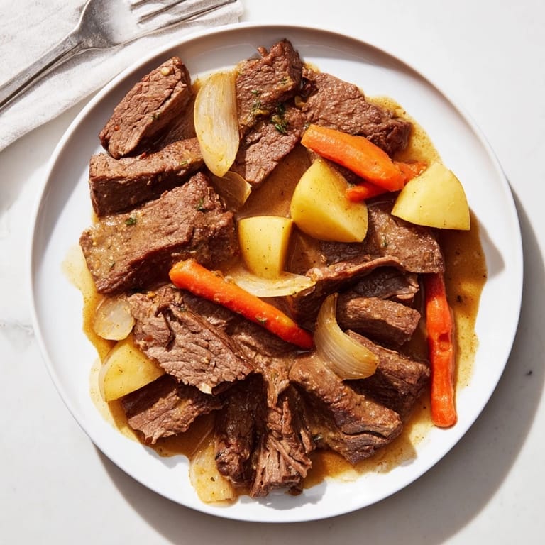 Golden-brown Beef Pot Roast with chunky potatoes and carrots, bubbling in a savory sauce in a Dutch oven.