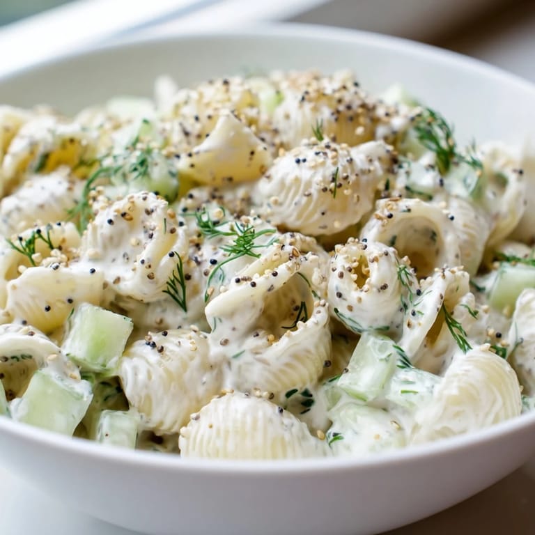Cucumber Crunch Pasta Salad served chilled in a white bowl, garnished with fresh dill for a refreshing summer side.