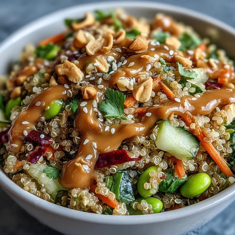 Serving suggestion for Thai Coconut Quinoa Bowl in a ceramic bowl, highlighting crunchy vegetables and a side of zesty peanut dressing.