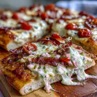 Golden flatbread pizza topped with roasted turkey, crispy bacon, juicy tomatoes, and creamy Mornay sauce for a Kentucky Derby-inspired meal.
